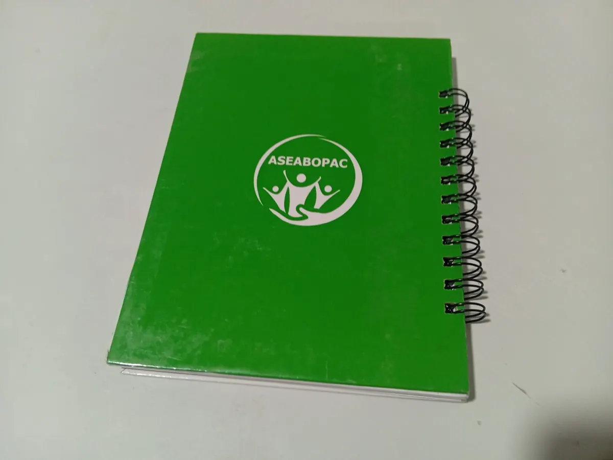 Contraportada verde de cuaderno con el logo de ASEABOPAC en blanco y laminado brillante