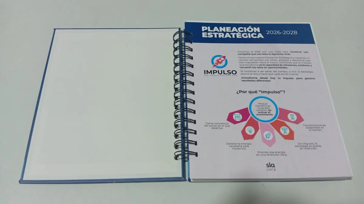 Cuaderno corporativo abierto con inserto a full color de planeación estratégica en la primera página