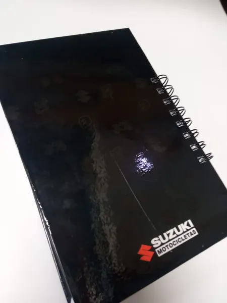 Cuaderno de tapa negra brillante con espiral doble O y logotipo en la esquina