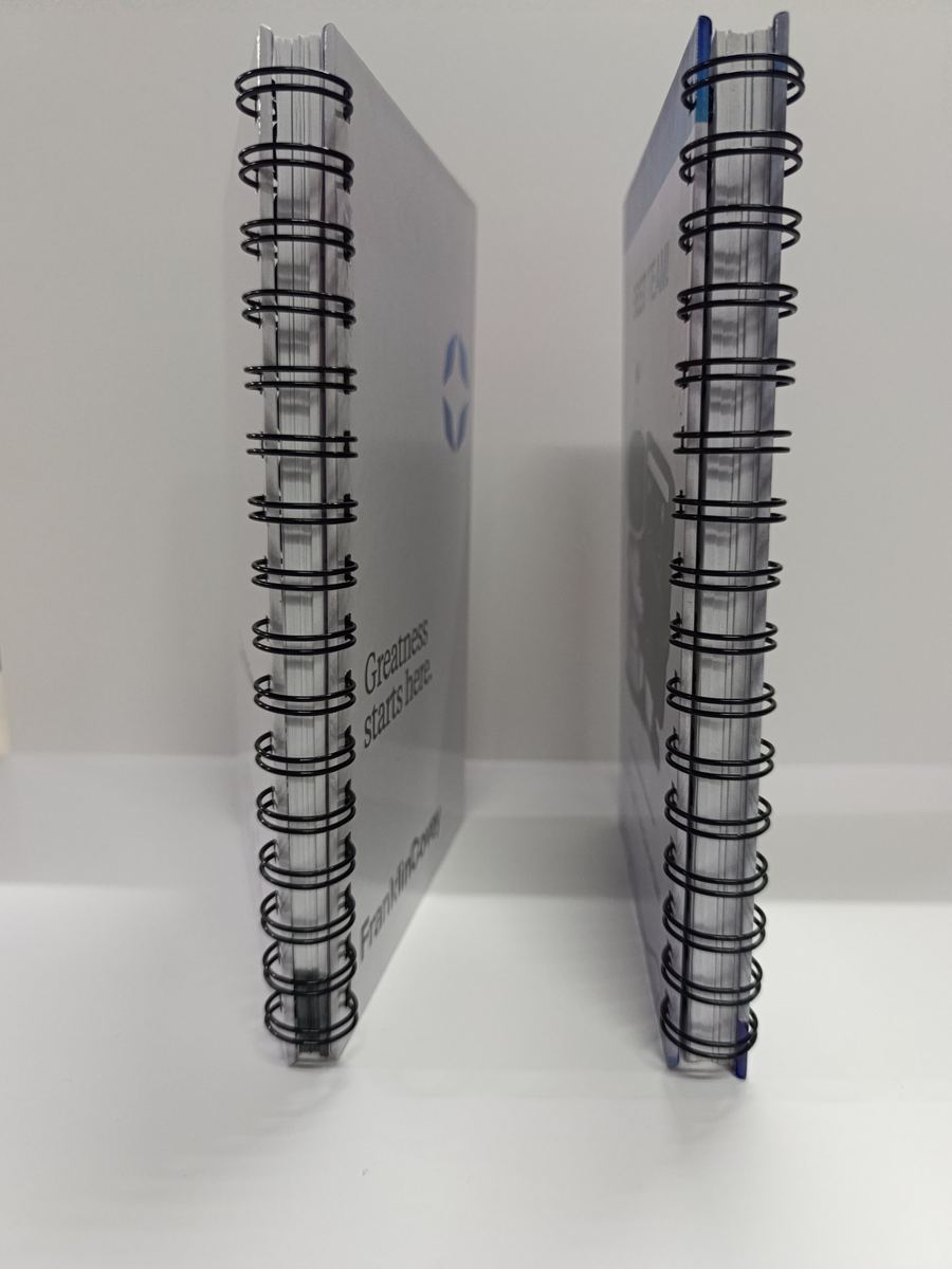 Detalle del lomo de dos cuadernos con encuadernación metálica doble O negra