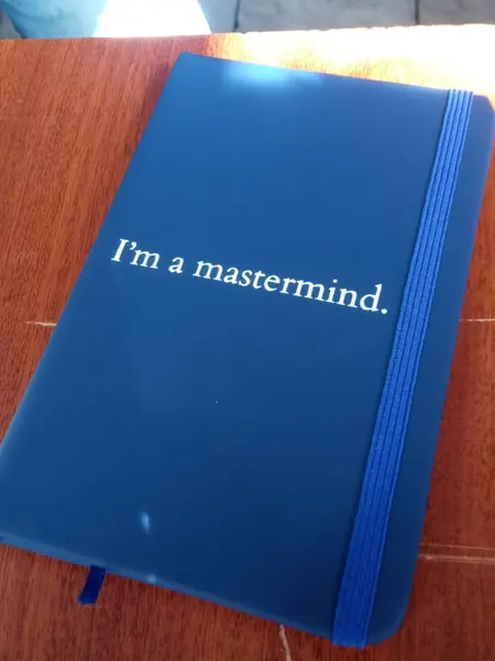 Libreta azul con elástico y una frase impresa en blanco
